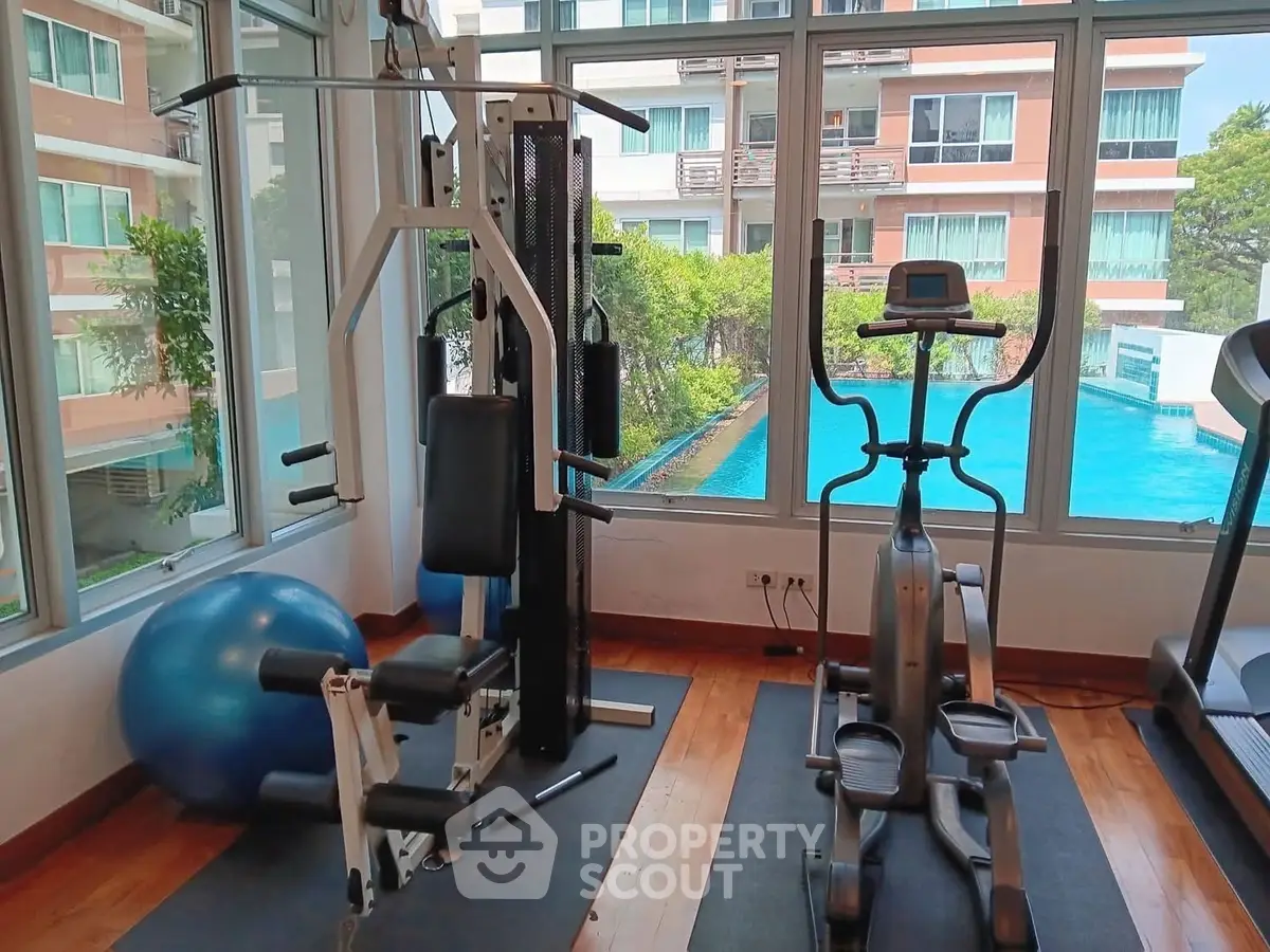 Modern gym with pool view in luxury apartment complex