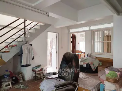 Spacious interior with staircase and cozy seating area, ideal for creative renovation.