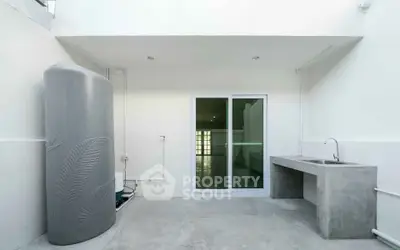 Modern minimalist outdoor space with concrete sink and water tank
