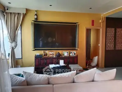 Luxurious living room with elegant decor and large wall-mounted TV, perfect for relaxation and entertainment.