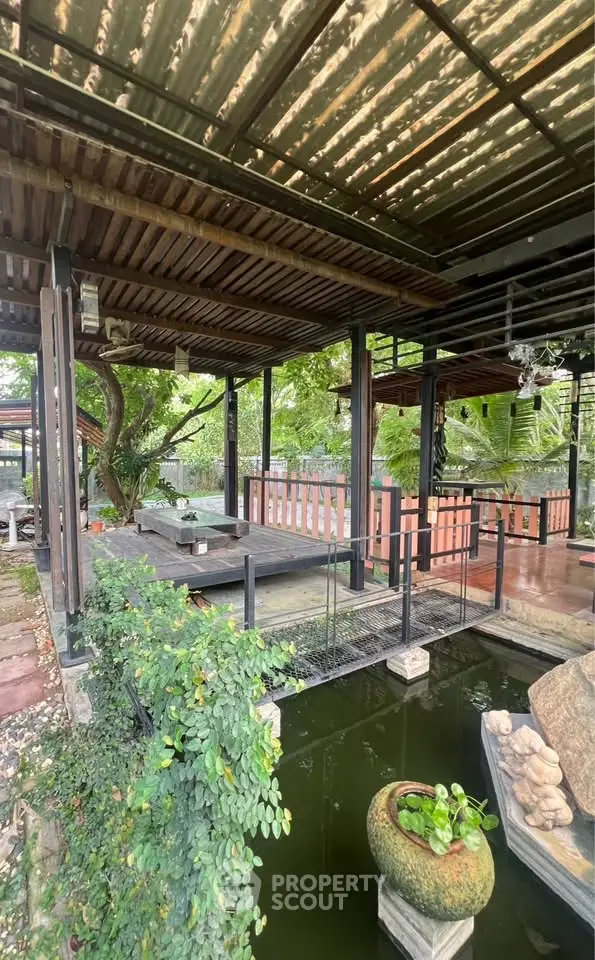 Charming outdoor garden area with rustic wooden deck and lush greenery, perfect for relaxation and entertaining.