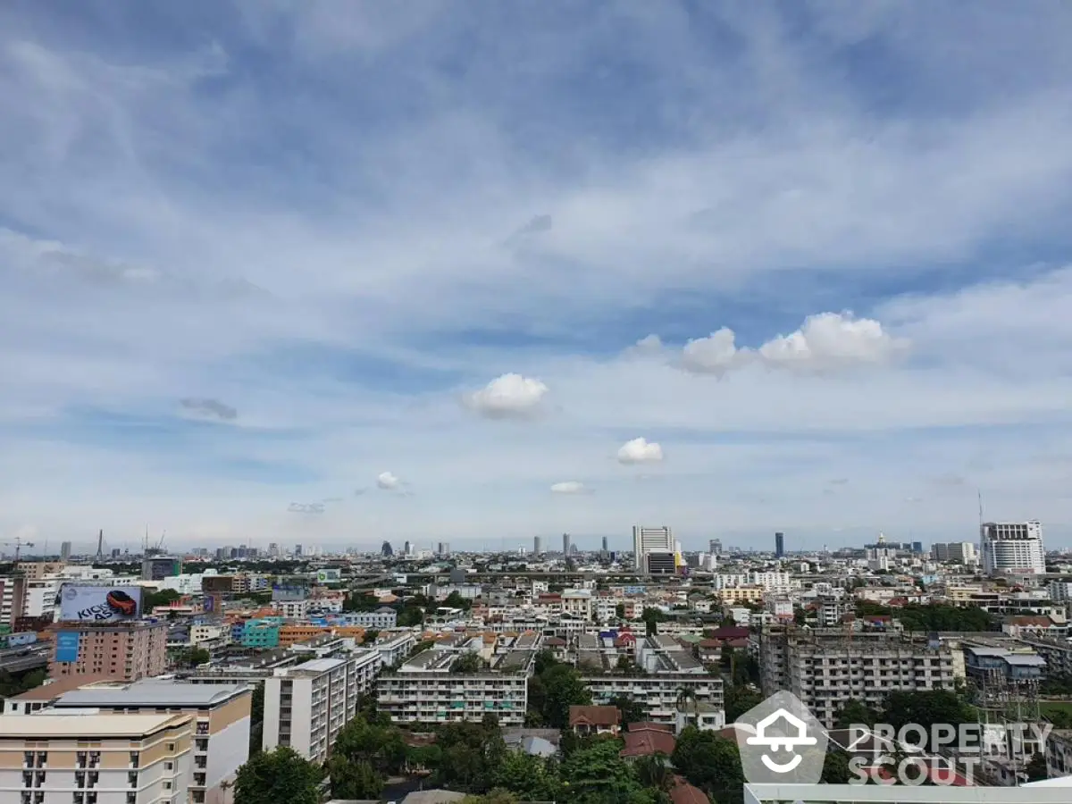 Stunning cityscape view from high-rise building showcasing urban skyline under blue skies.