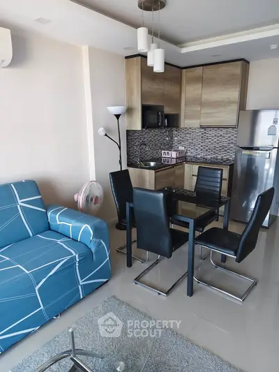 Modern open-layout kitchen and living room with stylish furniture and appliances.