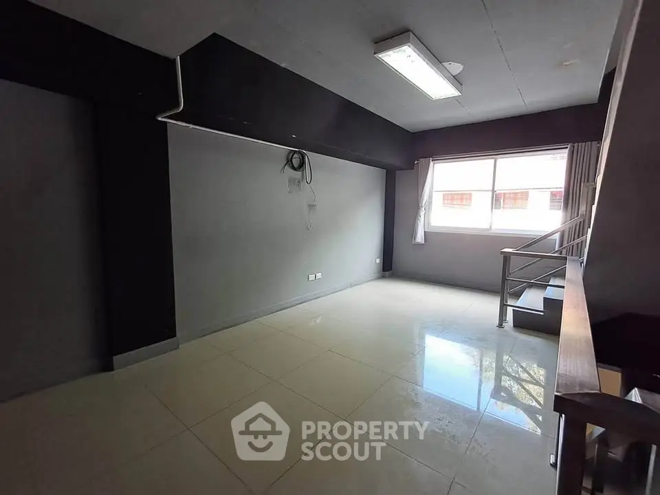 Spacious modern living room with large window and sleek tile flooring