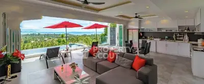 Luxurious open-plan living room with stunning pool and ocean view, modern kitchen, and stylish decor.