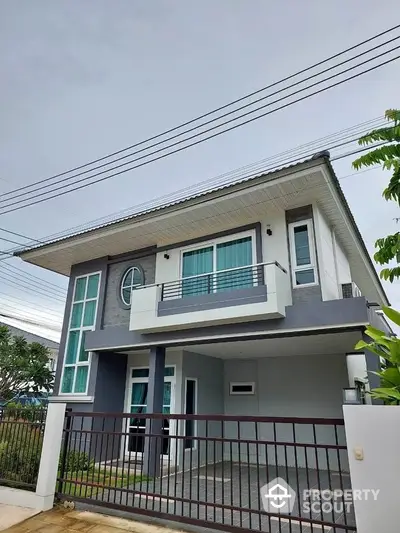 Modern two-story house with sleek design and spacious balcony in a serene neighborhood.