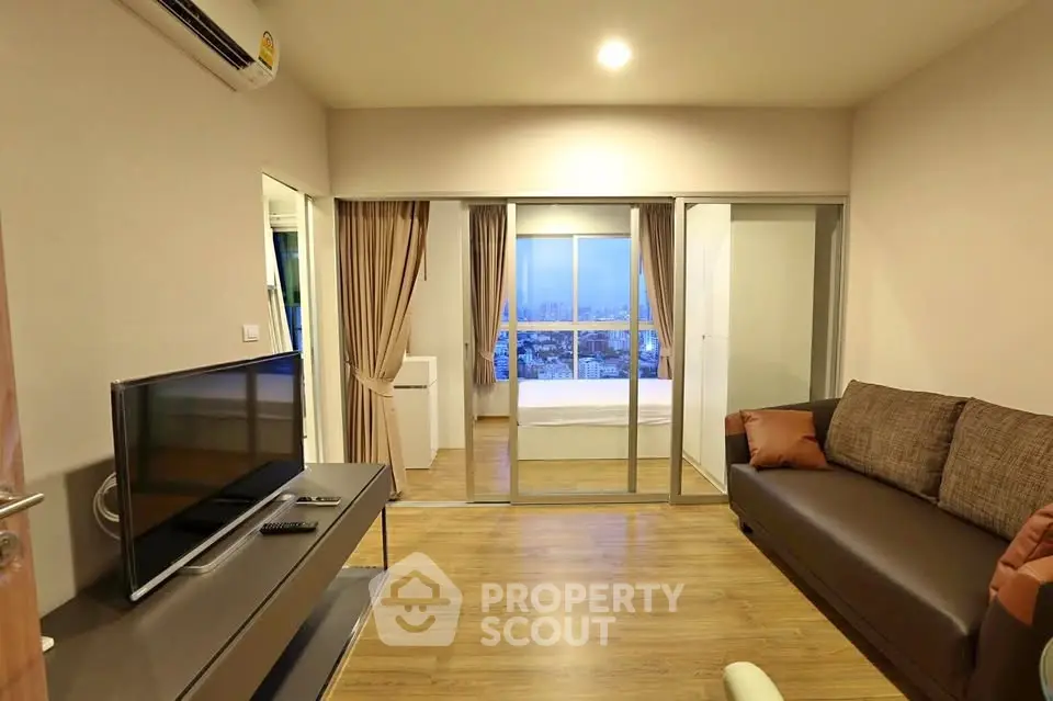 Modern living room with wooden flooring and city view in high-rise apartment