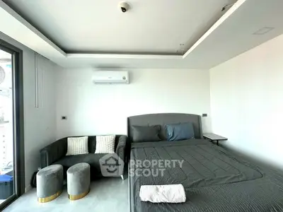 Modern bedroom with stylish decor and city view, featuring a cozy bed and elegant seating area.