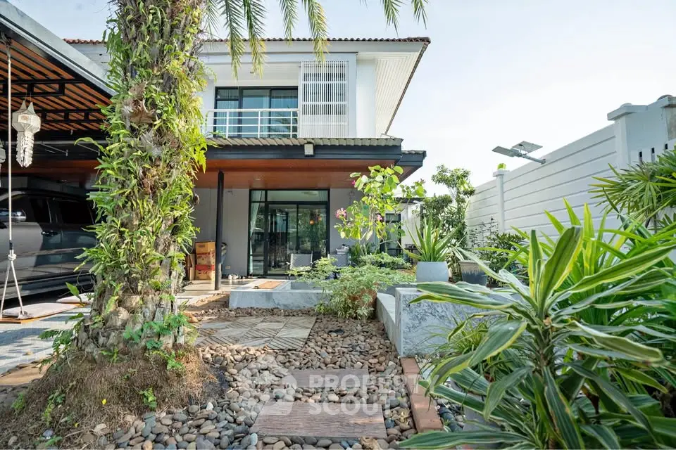 Modern two-story house with lush garden and spacious carport