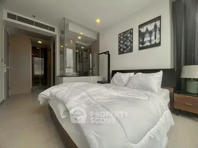 Modern bedroom with glass-enclosed bathtub and stylish decor