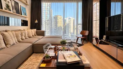 Luxurious living room with stunning city view, modern decor, and cozy seating area.