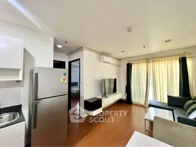 Modern living room with sleek furniture and natural light, featuring a stylish kitchen area and cozy ambiance.