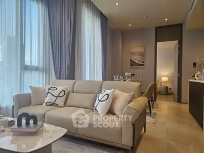 Luxurious modern living room with elegant decor and dining area, featuring floor-to-ceiling windows and plush seating.