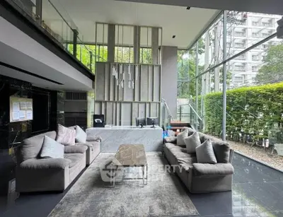 Luxurious modern living room with large windows and stylish furniture in a high-rise building.