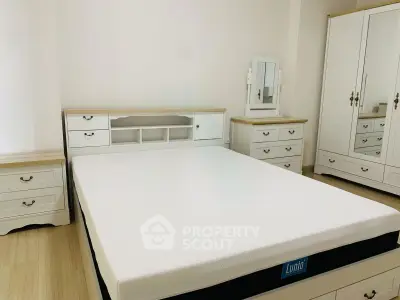 Spacious bedroom with elegant white furniture and comfortable mattress