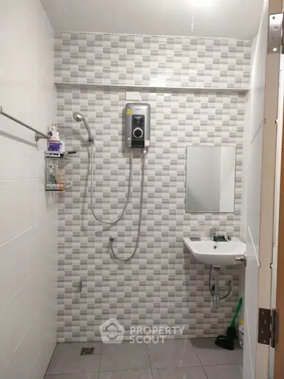 Modern bathroom with tiled walls, shower, and sink, ideal for compact living spaces.