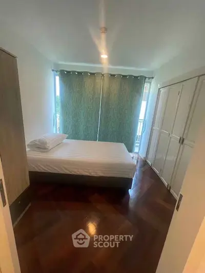 Cozy bedroom with wooden flooring and ample closet space, perfect for a restful retreat.