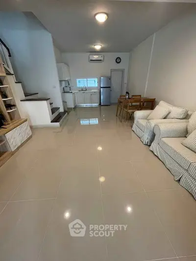 Spacious open-plan living room with modern kitchen and cozy seating area