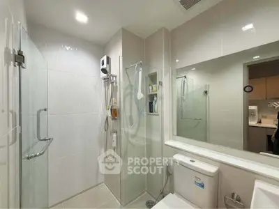 Modern bathroom with glass shower and sleek fixtures in a contemporary home.