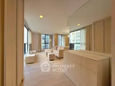 Spacious modern living room with large windows and elegant decor in a luxury apartment.