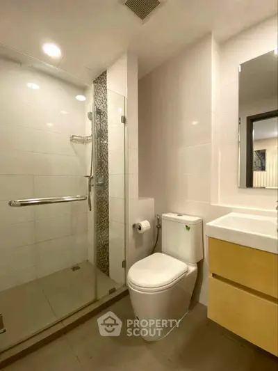 Modern bathroom with glass shower and sleek fixtures in a contemporary home.
