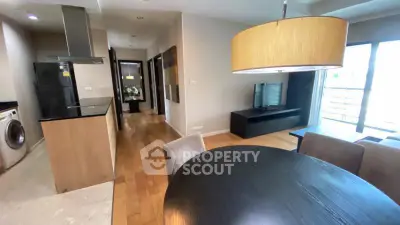 Modern open-plan living room and kitchen with stylish furniture and natural light.