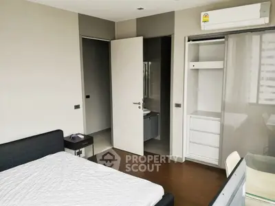 Modern bedroom with ensuite bathroom and built-in wardrobe, featuring sleek design and natural light.