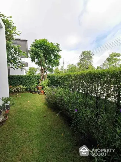 Charming garden view with lush greenery and well-maintained hedges in a serene residential area.