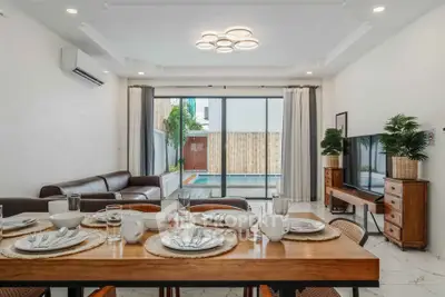 Luxurious living room with pool view, modern decor, and elegant dining setup.