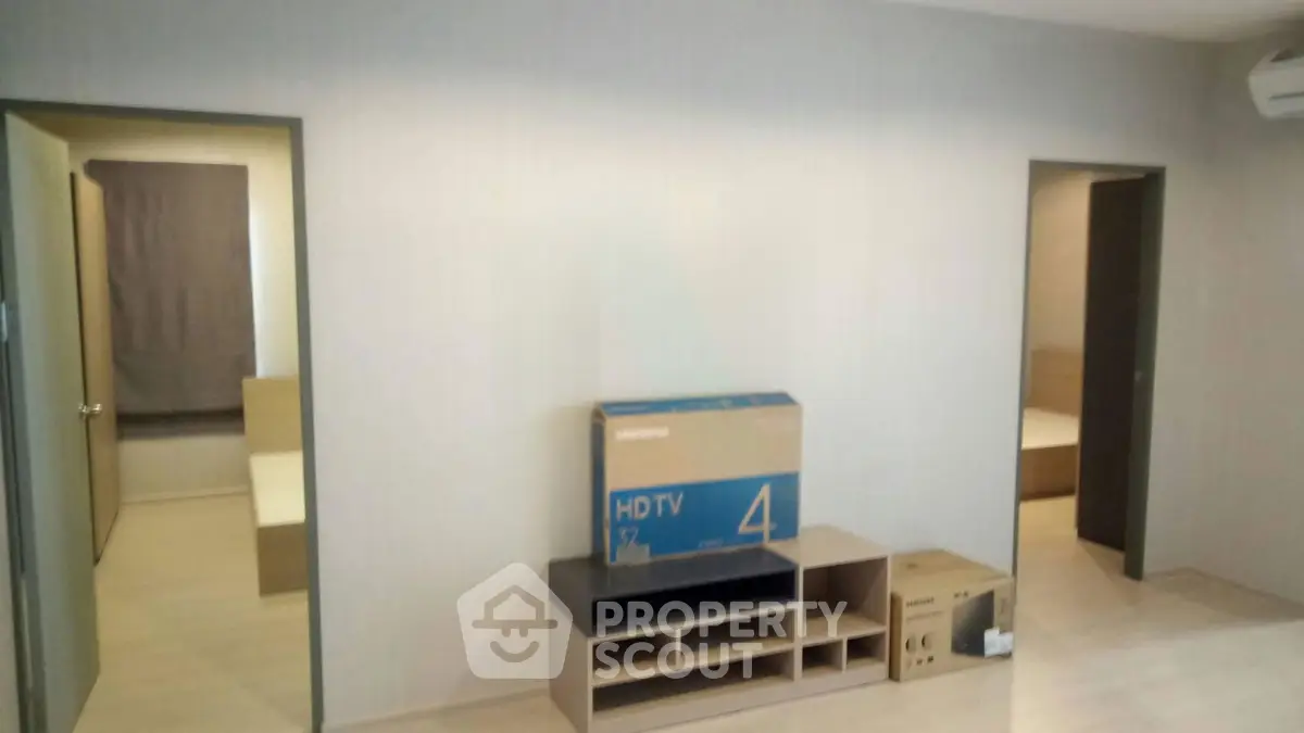 Spacious living room with modern furniture and two bedrooms, ideal for comfortable living.