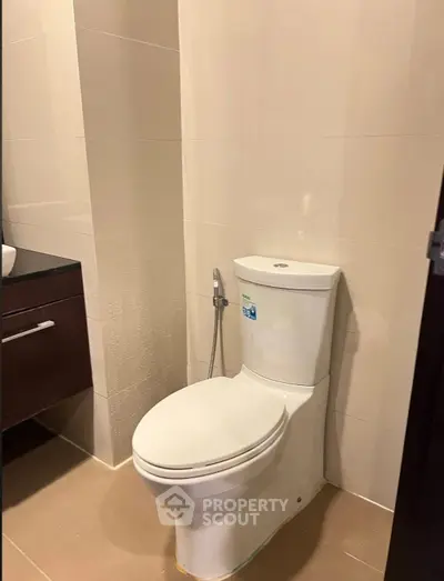 Modern bathroom with sleek toilet and stylish vanity in contemporary home.