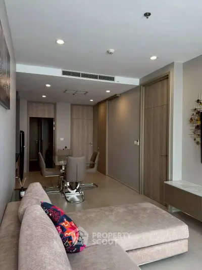 Modern living room with stylish decor and dining area in open layout apartment.