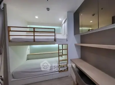 Modern compact bedroom with bunk beds and sleek storage solutions.