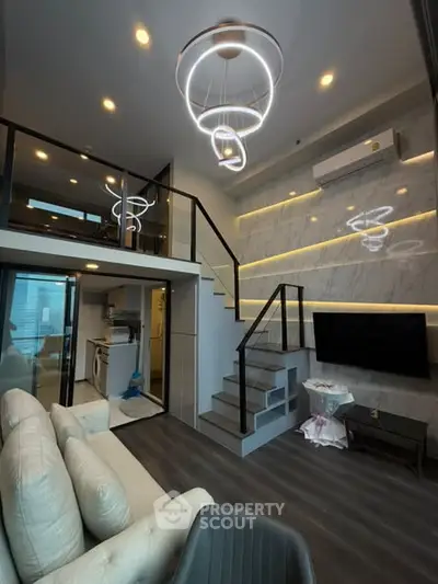 Modern loft-style living room with elegant lighting and open kitchen design.