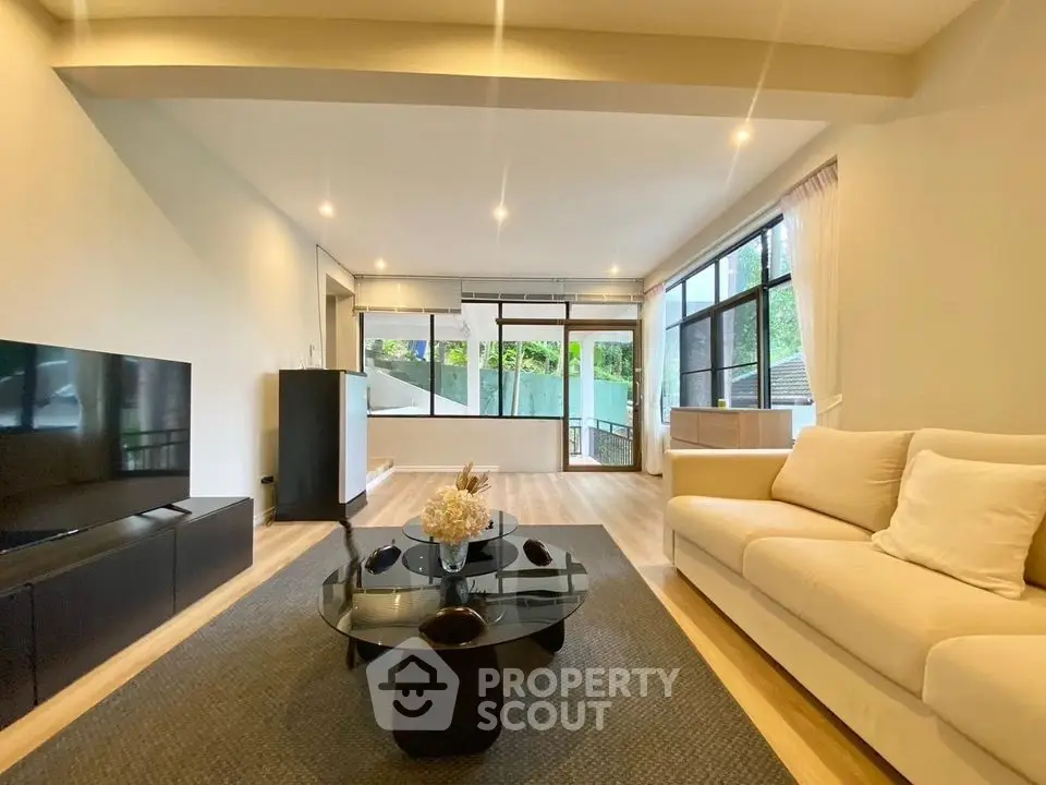 Spacious modern living room with large windows and elegant decor