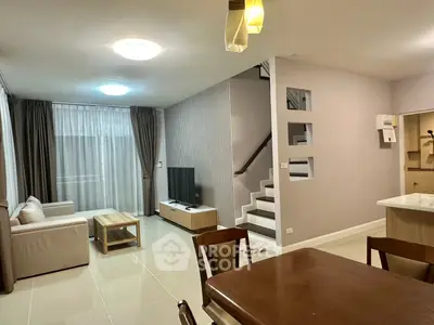 Spacious modern living room with elegant staircase and open dining area