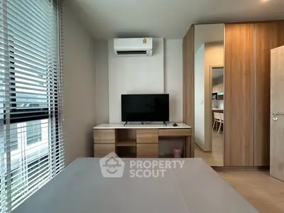 Modern bedroom with TV, air conditioning, and wooden wardrobe in stylish apartment.