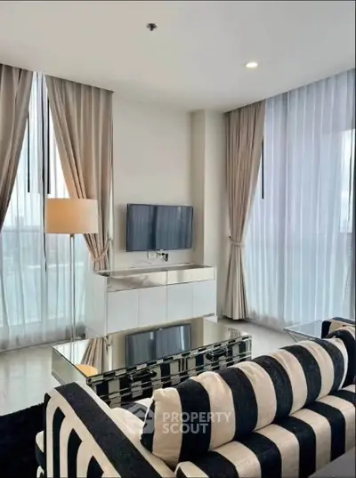 Modern living room with striped sofa and floor-to-ceiling windows