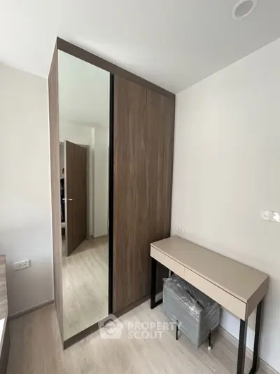 Modern bedroom with sleek wardrobe and stylish desk, perfect for contemporary living.