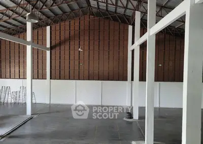 Spacious industrial warehouse with high ceilings and metal beams.