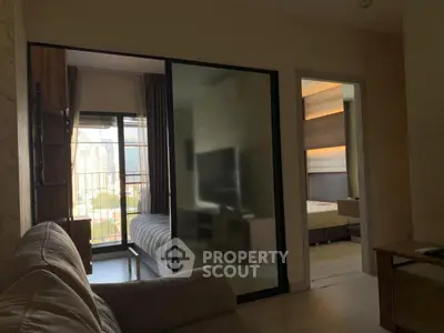 Modern apartment interior with cozy living room and bedroom view, featuring stylish decor and natural light.
