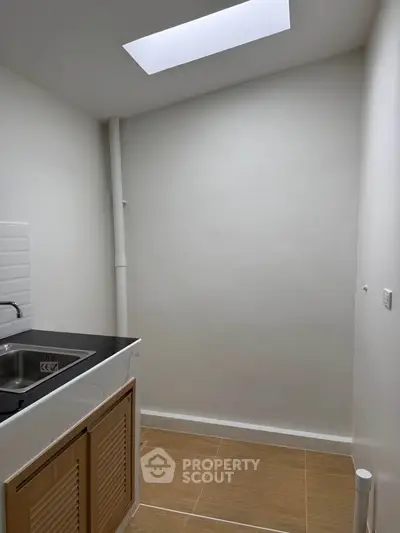 Modern kitchen with sleek design and skylight, featuring a compact layout and stylish cabinetry.