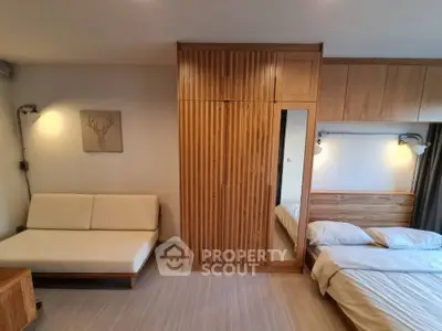 Spacious bedroom with wooden wardrobe and cozy bed in modern apartment