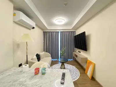 Modern living room with sleek furniture and stylish decor, featuring a wall-mounted TV and cozy seating area.