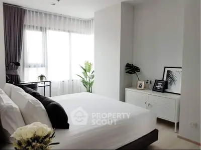 Modern bedroom with large window, stylish decor, and natural light