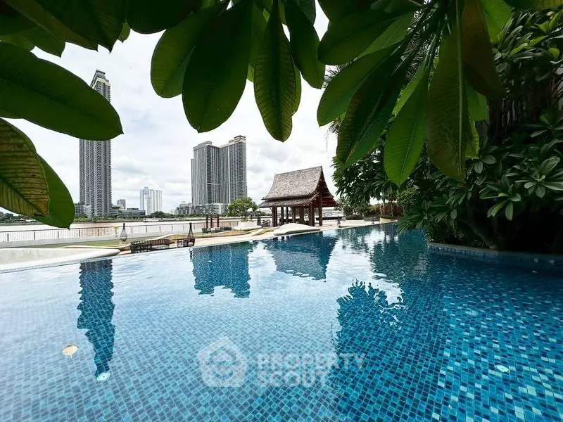 Luxurious infinity pool with stunning cityscape view and lush greenery, perfect for relaxation and leisure.