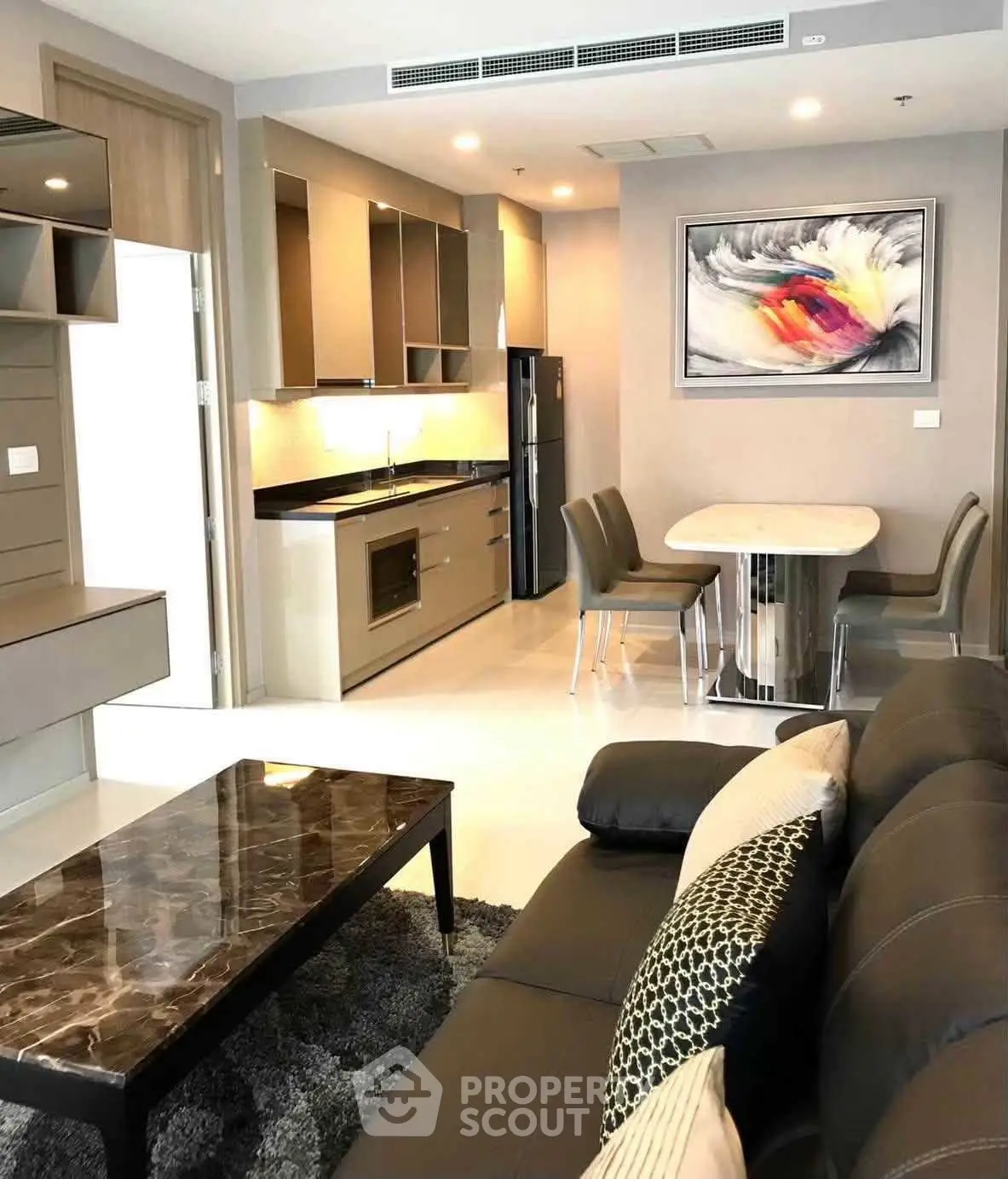 Modern living room with open kitchen, stylish decor, and cozy seating area in a contemporary apartment.