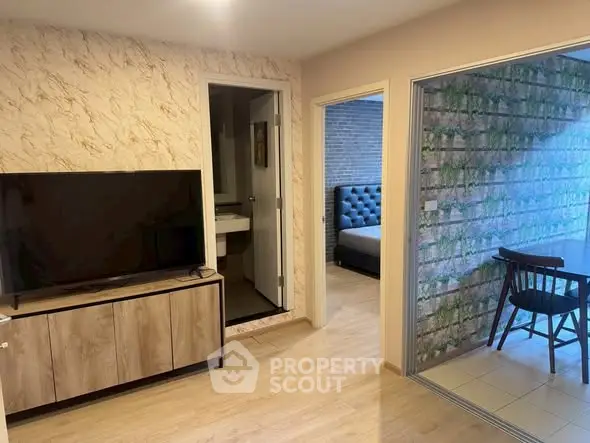 Modern apartment interior with TV, bedroom, and dining area showcasing stylish decor.