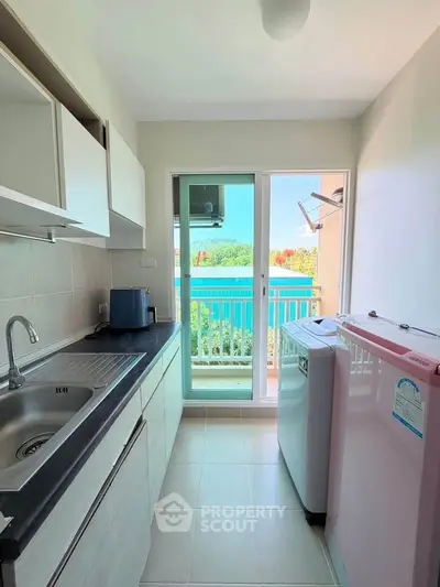 Modern kitchen with washing machine and balcony view