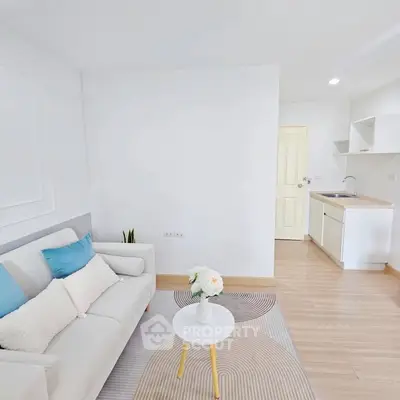 Bright and modern living room with cozy sofa and compact kitchen area, perfect for urban living.